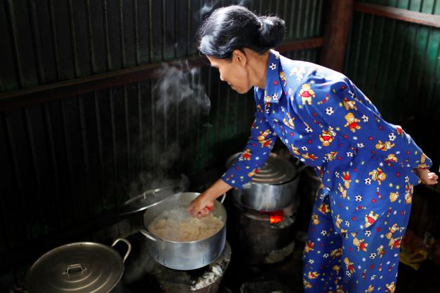 Femme Asiatique cuisinant dans une petite entreprise. Copyright: Godong