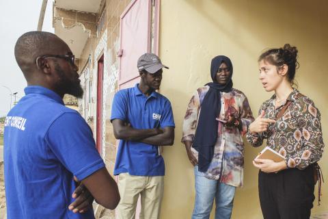 Quatre personnes en train de discuter debout contre un mur